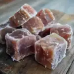 Frozen salted caramel candies on wooden surface, close-up, delicious treat, handmade caramel sweets, ideal for snacking and dessert.