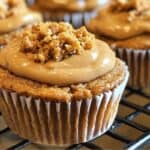 Creamy caramel frosting topped with a crumbly streusel, resting on a moist, spiced cupcake, perfect for dog-friendly baked treats and dessert recipes.