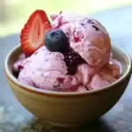 Creamy berry ice cream with fresh strawberries and blueberries in a bowl, ideal for dog-friendly desserts and treats. Perfect for pet owners to enjoy healthy, natural snacks with their dogs.