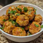 Savory meatballs with herbs in a white bowl, close-up of homemade meatball dish for dog treats, healthy canine meal, Waggy Chef recipe, nutritious dog food option.
