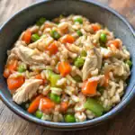 Sick with vegetables and chicken in a bowl, healthy homemade chicken and vegetable rice dish, fresh ingredients, nutritious, balanced meal, savory well-cooked home-cooked food.