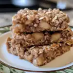 Butter pecan oat bars with apple chunks, homemade healthy energy snack, gluten-free fruit dessert, chewy oat bar recipe, nutritious and delicious baked oat treat.