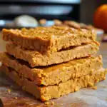 Pumpkin spice granola bars stacked on parchment paper, perfect for healthy snacks. Delicious, homemade, and nutritious, great for on-the-go energy and a tasty treat for all ages.