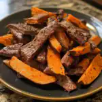 Succulent beef and roasted sweet potatoes seasoned with black pepper on a black plate, ready to serve, highlighting flavorful,healthy dog-friendly cooked meat and vegetable meal from Waggy Chef.