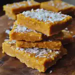 Sweet potato coconut bars with shredded coconut topping, healthy vegan dessert, gluten-free treat, rich in fiber and nutrients, perfect for snacking or sharing at gatherings.