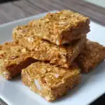 Chewy oatmeal bars with caramel and nuts on white plate, homemade healthy snack, gluten-free, high-fiber protein bars, easy to make at home.