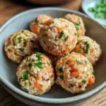 Savory homemade dog meatballs with carrots, rice, and herbs in a ceramic bowl, perfect for pet nutrition and treats.