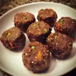 Savory vegan lentil and vegetable meatballs on white plate, nutritious plant-based protein, healthy vegetarian dishes, gluten-free, high-fiber meal options, Waggy Chef vegan recipes.