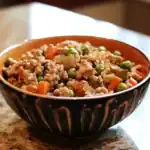 Savory homemade ground beef and vegetable stew in a decorative bowl, featuring peas, carrots, and onions, perfect for dog food made with Waggy Chef ingredients for nourishing pet meals.
