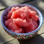 Fresh watermelon sorbet in decorative bowl, ideal summer treat, showcasing vibrant pink color and icy texture. Perfect for healthy dessert recipes or cooling off on hot days.