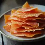 Crunchy caramelized dog treats topped with sea salt on a white ceramic plate for pet snack lovers.