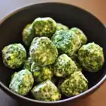 Fresh frozen spinach balls in a black bowl, ready for cooking or seasoning. Perfect for healthy dog treats or nutritious snacks with natural ingredients. Dietary-friendly and easy to prepare.