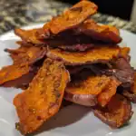 Crispy roasted sweet potato chips with spices, healthy snack.