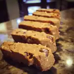 Chewy chocolate chip cookie bars with oats on a granite countertop, close-up.