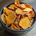 Sweet potato chips, healthy snack, crispy baked sweet potato slices in black bowl, Waggy Chef, gluten-free and vegan-friendly snack, tasty roasted sweet potato chips in snack bowl, perfect for healthy eating.