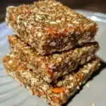 Dense homemade oatmeal energy bars with nuts, seeds, and dried fruits, perfect for a healthy snack or quick energy boost. Great for on-the-go athletes and busy lifestyles.