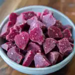 Freshly cut frozen red beets in a white bowl, showcasing vibrant color and texture. Perfect for healthy snacks, salads, and smoothies, these organic beets are a nutritious addition to any diet.