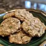 Oatmeal dog biscuits with oats and herbs on a decorative ceramic plate, healthy homemade treat for dogs, Waggy Chef pet treat recipe, fresh and nutritious dog snack.