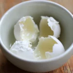 Cream cheese in a white bowl, ready to use for cooking or baking, soft and creamy texture.