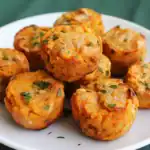 Savory vegan lentil and vegetable protein stuffed muffins garnished with fresh herbs on a white plate, healthy plant-based appetizer, nutritious gluten-free vegan snack options.