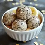 Chewy black sesame protein balls in a white ramekin, perfect for healthy snacks or desserts. Nourishing, gluten-free, and packed with flavor. Ideal for on-the-go energy and nutritious treat options.