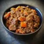 Savory beef and vegetable stew with quinoa in a black bowl, perfect for healthy pet meals or dog food. Nutrient-rich homemade recipe for canine nutrition and wellness.