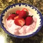 Fresh strawberry fruit salad in a decorative bowl, topped with ripe strawberries and creamy yogurt, perfect for a healthy snack or dessert. The vibrant colors highlight fresh, juicy strawberries and smooth yogurt.
