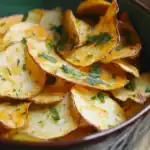 Crispy seasoned potato chips garnished with chopped parsley in a rustic bowl, perfect snack or appetizer, homemade baked potato chips, crunchy and flavorful snacks, healthy alternative to store-bought chips.