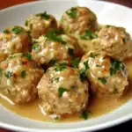 Tender beef meatballs in a savory sauce topped with fresh chopped parsley, served in a white bowl for a delicious Waggy Chef pet meal.