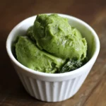 Creamy homemade pistachio ice cream in a white ramekin, showcasing a vibrant green color and smooth texture. Perfect for pet owners and dog lovers seeking healthy, pet-friendly frozen treats.