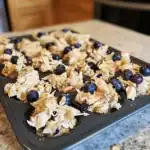 Blueberry and coconut muffin batter in a muffin tin for baking.