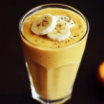 Creamy banana and turmeric smoothie with chia seeds in a tall glass, healthy and delicious beverage. Perfect for breakfast or a nutritious snack, packed with vitamins and antioxidants.