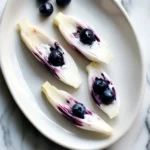 Fresh endive lettuce cups topped with blueberries and creamy yogurt, a healthy and delicious pet-friendly treat perfect for dogs.