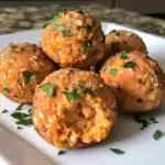 Crispy baked falafel balls garnished with chopped parsley on a white plate, showcasing a healthy vegetarian and vegan Middle Eastern dish. Perfect for a nutritious snack or meal.