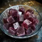 Juice cubes in a glass bowl, perfect for summer refreshment or added to drinks. Cool, colorful, and delightful, ideal for enhancing beverages or enjoying on hot days.