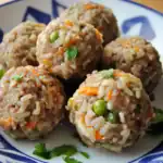 Savory meat and rice meatballs with vegetables served on a decorative plate, perfect for pet-friendly nutritious dog food.