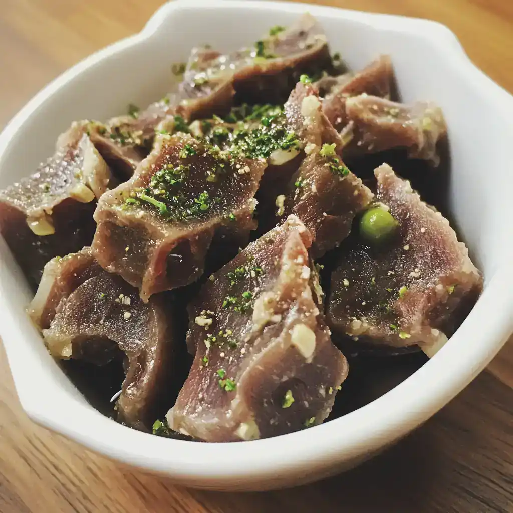 Succulent cooked beef short ribs topped with herbs and seasonings in a white bowl, ready for serving. Perfectly seasoned meat with tender texture, ideal for flavorful meals and gourmet dishes.