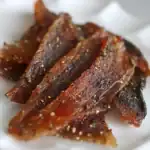 Savory beef jerky strips seasoned with black pepper, salt, and spices, perfect for dog treats or training rewards, showcasing Waggy Chef's gourmet pet snacks excellence.